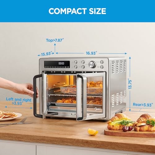 Compact air fryer oven on kitchen counter with open doors and food inside.
