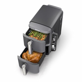 Dual-drawer air fryer with chicken and vegetables inside.